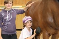 Das l�sst sich Pferd beim Pfingstfest des Reitclubs Fl�hatal gefallen: Sandra Sch�nherr (links) und Lena Rennwanz zeigen, wie ein Pferd gepflegt wird. Bunny l�sst sich derweil das Heu schmecken.  