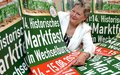 Renate Naumann mit Werbeplakaten 