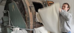 Volker Rabe, wissenschaftlicher Leiter des Gerbereitechnikums am Forschungsinstitut f�r Leder und Kunststoffbahnen, am sogenannten Trockenwalkfass von 1959. Hier werden die Leder nach dem Gerben und Trocknen durch Drehen in der Trommel wieder weich gemacht.