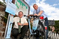 Hier geht es schon elektromobil zu: Reginald Fuchs (l.) von Envia zapfte f�r Hohestein-Ernstthals Oberb�rgermeister Erich Homilius auf dem Altmarkt den ersten Strom aus der E-Bike-Ladestation.  