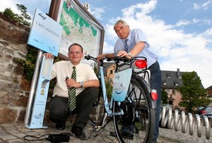 Hier geht es schon elektromobil zu: Reginald Fuchs (l.) von Envia zapfte f�r Hohestein-Ernstthals Oberb�rgermeister Erich Homilius auf dem Altmarkt den ersten Strom aus der E-Bike-Ladestation.  
