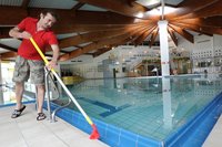 Olaf Gesse, Mitarbeiter einer Reinigungsfirma, s�ubert den Rand des 25-Meter-Beckens, um das neue Fliesen verlegt wurden.  