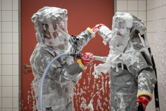 Bilder des Tages vom 10.06.2026 - Louise Götze (l) und Ursula Pfitzner, Intensivpflegerinnen und Koordinatorinnen auf der Sonderisolierstation der Charité, desinfizieren sich während eines Pressetermins nach der Rückkehr aus dem Patientenzimmer in der Schleuse mit einer Schaumlösung.