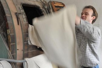 Volker Rabe, wissenschaftlicher Leiter des Gerbereitechnikums am Forschungsinstitut für Leder und Kunststoffbahnen, am sogenannten Trockenwalkfass von 1959. Hier werden die Leder nach dem Gerben und Trocknen durch Drehen in der Trommel wieder weich gemacht.