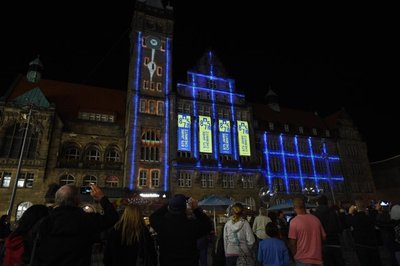 <p>Gespielt wurde mit den Bestandteilen des Logos für 875 Jahr Chemnitz. Außerdem wurden die Fenster wechselnd farbig hervorgehoben. Ein riesiger Zeiger aus Licht, unterhalb der Rathausuhr tickte und ließ die Jahrhunderte, fast mahnend, verstreichen.</p>
