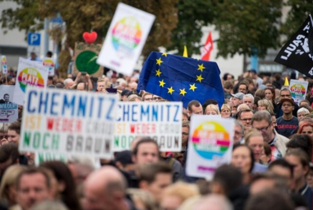 <p>Teilnehmer der Kundgebung des Bündnisses Chemnitz Nazifrei unter dem Motto «Herz statt Hetze» halten auf dem Parkplatz an der Johanniskirche Schilder und eine Flagge der EU hoch.</p>
