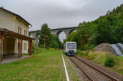 <p><span calibri="" style="font-size:11.0pt;line-height:115%;
font-family:">Die Brücke heute vom Haltepunkt Pirk der Vogtlandbahn aus gesehen.<span style="mso-no-proof:yes"><!--[if gte vml 1]><v:shapetype id="_x0000_t75"
 coordsize="21600,21600" o:spt="75" o:preferrelative="t" path="m@4@5l@4@11@9@11@9@5xe"
 filled="f" stroked="f">
 <v:stroke joinstyle="miter"/>
 <v:formulas>
  <v:f eqn="if lineDrawn pixelLineWidth 0"/>
  <v:f eqn="sum @0 1 0"/>
  <v:f eqn="sum 0 0 @1"/>
  <v:f eqn="prod @2 1 2"/>
  <v:f eqn="prod @3 21600 pixelWidth"/>
  <v:f eqn="prod @3 21600 pixelHeight"/>
  <v:f eqn="sum @0 0 1"/>
  <v:f eqn="prod @6 1 2"/>
  <v:f eqn="prod @7 21600 pixelWidth"/>
  <v:f eqn="sum @8 21600 0"/>
  <v:f eqn="prod @7 21600 pixelHeight"/>
  <v:f eqn="sum @10 21600 0"/>
 </v:formulas>
 <v:path o:extrusionok="f" gradientshapeok="t" o:connecttype="rect"/>
 <o:lock v:ext="edit" aspectratio="t"/>
</v:shapetype><v:shape id="Grafik_x0020_7" o:spid="_x0000_i1025" type="#_x0000_t75"
 style='width:285.75pt;height:189.75pt;visibility:visible;mso-wrap-style:square'>
 <v:imagedata src="file:///C:/Users/FISCHE~1/AppData/Local/Temp/msohtmlclip1/01/clip_image001.jpg"
  o:title=""/>
</v:shape><![endif]--><!--[if !vml]--><img height="253" src="file:///C:/Users/FISCHE~1/AppData/Local/Temp/msohtmlclip1/01/clip_image002.jpg" v:shapes="Grafik_x0020_7" width="381" /><!--[endif]--></span></span></p>
