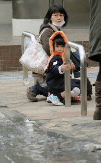 <p>
	Eine Mutter und ihr Kind versuchen sich auf einer Straße in Tokio in Sicherheit zu bringen.</p>
