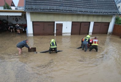 Helfer und Feuerwehrleute standen auf dem Hof an der Bachstraße am Samstag teilweise kniehoch in der braunen Brühe. 