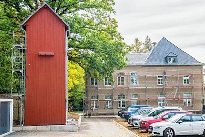 Der Schlauchturm heute, frisch gestrichen. Zusätzlich zu den bereits an der Außenwand zu erkennenden Nistkästen sollen weitere Nistmöglichkeiten für Vögel entstehen. Im Hintergrund ist das Rathaus zu sehen. 