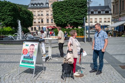 Kleiner Stand auf dem Altmarkt: CDU-Kandidat Marcus Hoffmann im Gespräch mit einer Bürgerin.
