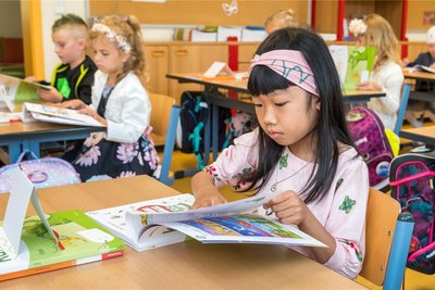 Probesitzen im künftigen Klassenraum und schon mal in den neuen Schulbüchern blättern durften die Kinder nach ihrer Aufnahmefeier am Samstagvormittag.