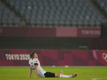 Cedric Teuchert sitzt nach dem Ausscheiden enttäuscht auf dem Rasen.