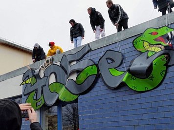 Um auf die Blockparty im High-Point aufmerksam zu machen, hatten die Musiker ihr von einer Schlange geprägtes Logo am Jugendclub angebracht.