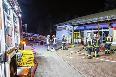 Einsatzkräfte der Feuerwehr vor dem Getränkemarkt am Roten Mühlenweg in Schwarzenberg-Sachsenfeld. 