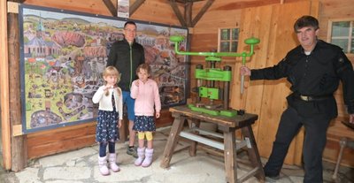 Lars Münzner (links) aus Grünhain mit seinen Töchtern Rania (links) und Felipa an der Münzpräge am Schaubergwerk "Herkules-Frisch-Glück" mit Bergführer Ulrich Lang. 