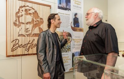 Besonderer Blickfang der Ausstellung "Sachsens Glanz": das von Holzgestalter Tobias Michael (rechts) aus Lauter aus Mahagoni und Lindenholz gestaltete Porträt Ludwig van Beethovens. Es weist im begehbaren Programmheft auf ein Konzert in Schneeberg hin. Das fasziniert auch Bastian Guthke (links) von den Städtischen Museen. 