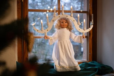 Diese moderne Lichterpuppe, angelehnt an die Crottendorfer Lichterpuppe, steht in einem Gelenauer Fenster. Sie hat geschnitzte Hände.