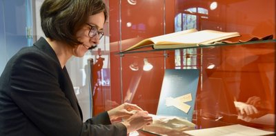 Esche-Museumsleiterin Barbara Wiegand-Stempel richtet eine Vitrine der Sonderschau über Oberfrohnas Historie ein, die auch Handschuhe aus der Firma Hermann Dittrich auf der Frohnbachstraße zeigt. 