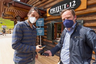 Philipp Heinrich, Inhaber des Restaurants "Prijut 12", und Covid-Exit-Projektmanager Erik Schulze (v. l.) demonstrieren, dass im einfachsten Fall ein Smartphone genügt, um sich registrieren zu lassen. 
