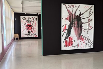 Blick in die Ausstellung auf Werke von Meese: „Kampf im Meese! (Verbunkerung)“ (Vordergrund) und „Kampf um Mutterz, was passiert? (Was bei dir los?)!“