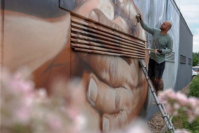 "In guten Händen" - so lautet künftig die Botschaft an der Garagenfront des Sächsischen Krankenhauses in Rodewisch, an der Graffitikünstler Nico "CEBU" Roth gerade arbeitet. Ende nächster Woche soll das Werk fertig sein und dann richtig "leuchten", verspricht Roth.