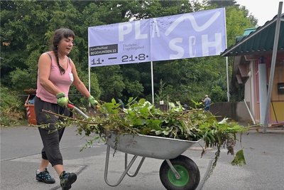 Viele fleißige Helfer packen mit an. So auch Susanne Kretzschmar aus Thalheim, die eine Schubkarre voll Grünschnitt schiebt.