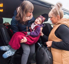 Keine leichte Angelegenheit: Romy Wohlgemuth muss Deborah aus dem Kindersitz (rechts: Fahrerin Katrin Köhler) heben und sie dann ins Haus tragen.