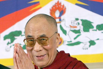 Der Dalai Lama, das geistige Oberhaupt der Tibeter, vor einer tibetischen Flagge.