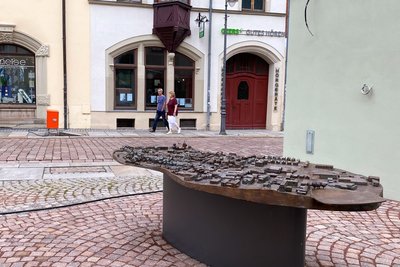 An der Quergasse in Mittweida wird an eine Hausfassade im Herbst noch ein Zeitstrahl gehängt, auf dem dargestellt wird, wie Mittweida sich von der Stadtgründung bis heute entwickelt hat.