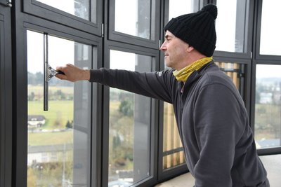 Torsten Zimmermann von der Metallbau-Firma Wimmer aus Zeulenroda-Triebes putzt die neuen Fenster.