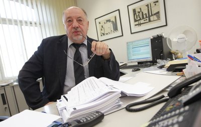 Hellfried Unglaub in typischer Pose an seinem Schreibtisch. Wenn er zu laut beschimpft wird, bietet er gerne ein Glas Milch an.