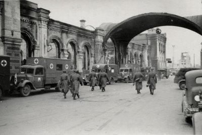 Deutsche Soldaten und Sanitätsfahrzeuge der Wehrmacht am Bahnhof im besetzten Smolensk in Russland.