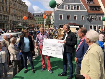 Jörg Graichen (r.), Werkleiter bei Brose, überreicht dem Förderverein des August-Horch-Museums Zwickau die Spende.