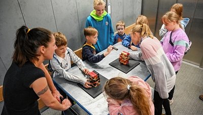 Jutta Boehme zeigt den Kindern mithilfe eines Geschicklichkeitsspiels, wie ruhig der Lastenaufzug fährt, der sonst Exponate transportiert.