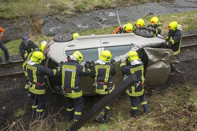 Die Feuerwehrmänner versuchen mit vereinten Kräften die Fahrbahn der Preßnitztalbahn zu räumen.