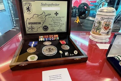 Zu sehen sind ein Traditionskrug sowie Abzeichen und Medaillen, die ein Bundeswehrangehöriger erhalten hat.