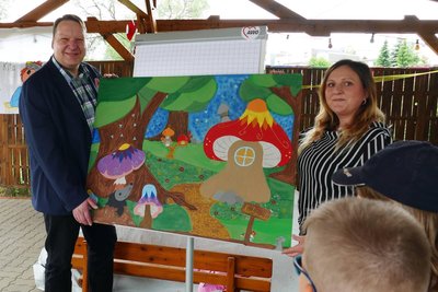 Jens Gundermann vom Awo-Kreisverband und Kita-Leiterin Anika Nestler präsentieren das Bild, mit dem der neue Name „Märchenwald“ verkündet wurde.