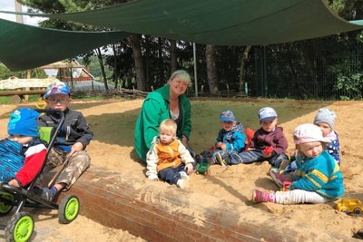 Ihren neuen Sandspielplatz haben die Kita-Kinder, hier einige der Jüngsten mit Erzieherin Katrin Peters, schon in Besitz genommen.