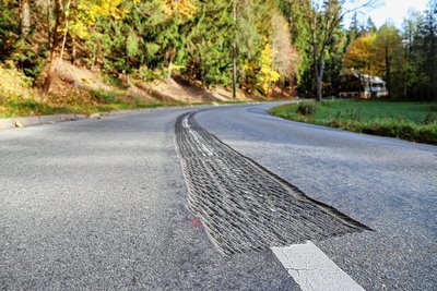 Der weiße Mittelstreifen auf dem sich wölbenden Asphalt war "verwackelt". Daraufhin wurde entschieden, ihn dort abzufräsen, wo er nicht mehr gerade erschien. 