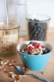 Am besten mit dem Frühstück starten: Haferflocken und Beeren bringen eine Extra-Portion Ballaststoffe in den Morgen. 