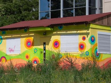            Ein bunter Container steht auf einer freien Fläche im Plattenbaugebiet Grünau in Leipzig. Hier soll zukünftig der Campus für die erste Gemeinschaftsschule in Sachsen entstehen.