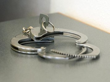            Handschellen liegen auf einem Tisch.