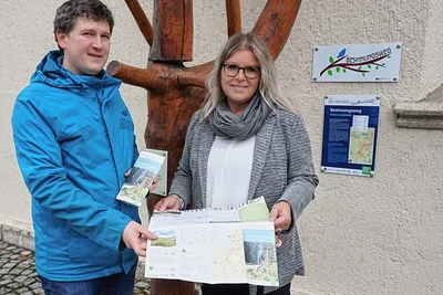 Kathrin Hoyer und Pfarrer Jan Dechert präsentieren den Flyer, den es nun zum Weg der Besinnung gibt. 