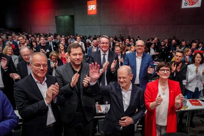 Olaf Scholz  (vorn) winkt beim außerordentlichen SPD-Bundesparteitag den Delegierten zu.