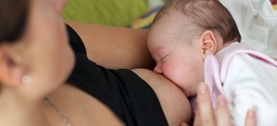 Eine Mutter stillt ihre sieben Wochen alte Tochter.