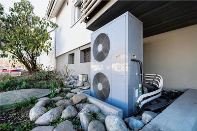 Die Lüftungsanlage einer Wärmepumpe an einem Wohnhaus. Mit dem geplanten Gebäudeenergiegesetz sollen solche Anlagen noch mehr an Bedeutung gewinnen. Doch der Gesetzentwurf steckt derzeit fest. 