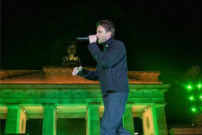 Clueso singt bei der Solidaritätskundgebung "Sound of Peace" am Brandenburger Tor auf der Bühne.