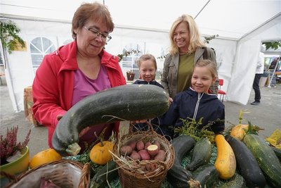 Andrea Steger vom Förderverein des Botanischen Gartens (links) spricht mit den Zwillingen Charlotte und Henriette (r.) und ihrer Mutter Marlene Hoffmann über gesundes Gemüse. Die Siebenjährigen und ihre Eltern waren schon öfters in der Einrichtung zu Gast.