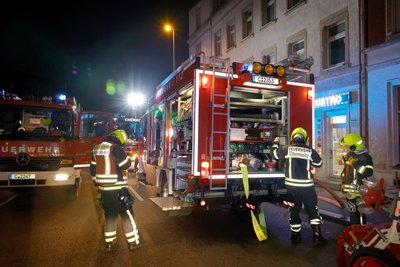 Einsatzkräfte der Feuerwehr vor der brennenden Wohnung in der Frankenberger Straße in Chemnitz.